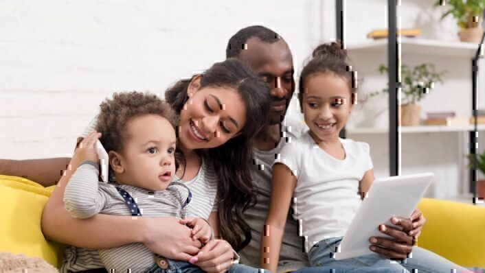 Happy Young Family Spending Time Together With Devices At Home