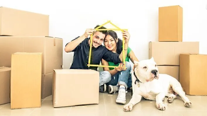 couple and dog with packaging boxes ready to move