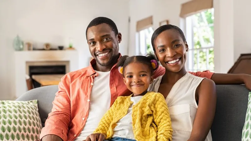 Young African American Couple with small child sitting on a couch