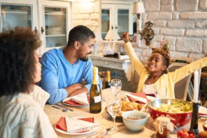 Family of three gathered around a holiday dinner table
