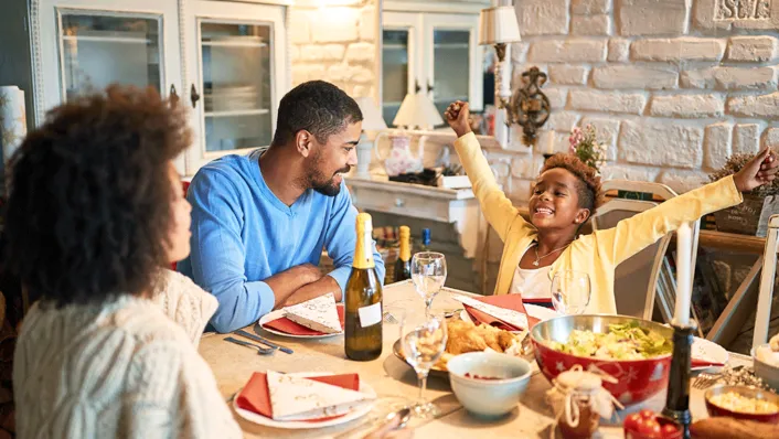Family of three gathered around a holiday dinner table