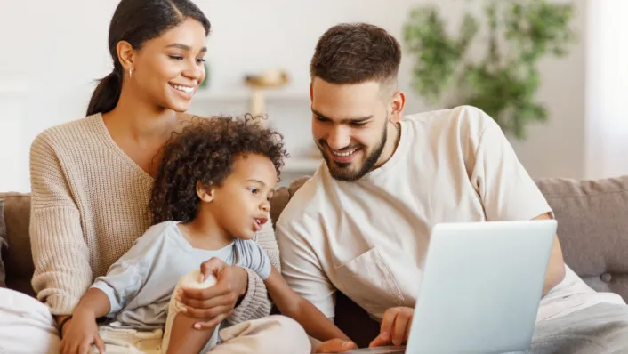 Family with laptop on couch, reviewing child tax credit info