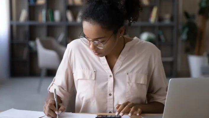 Una adulta joven completando la documentación para préstamos estudiantiles