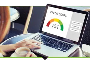 Person at coffee shop table with coffee, reviewing laptop displaying credit score image
