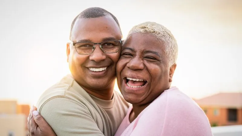 Happy senior couple embracing during sunset outside, facing the camera