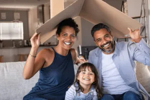 a family of three sitting in their livingroom
