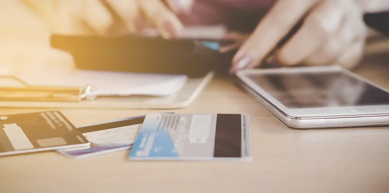 woman's hands with calculator, phone and credit cards