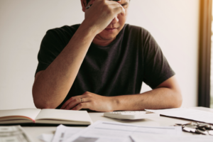 A stressed man looking over financial statements