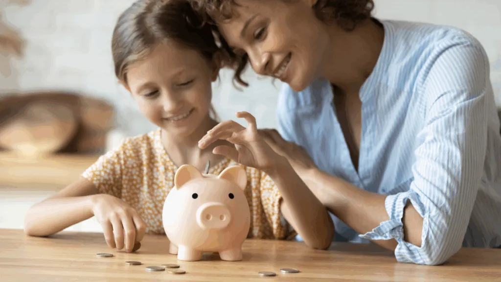 mom teaching daughter how to save money using a piggy bank