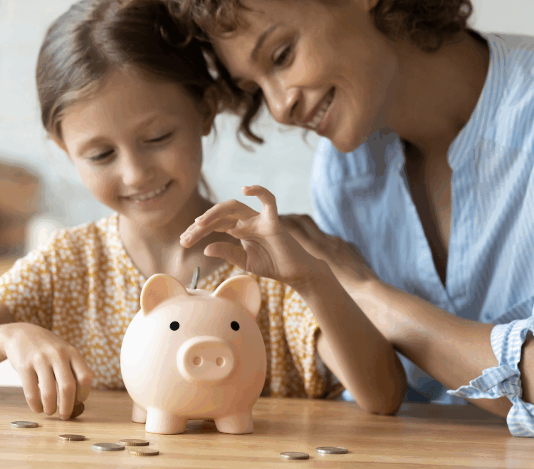 mom teaching daughter how to save money using a piggy bank