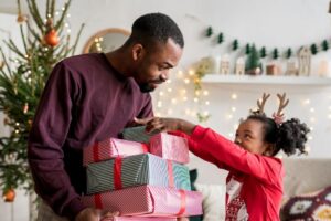 father giving daughter gifts during the holidays