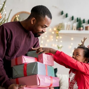 father giving daughter gifts during the holidays