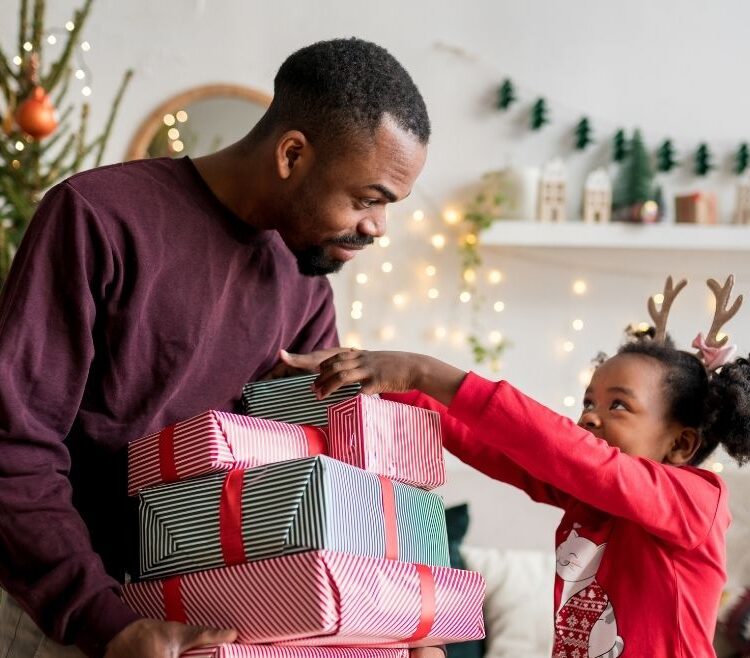 father giving daughter gifts during the holidays