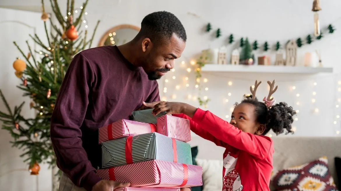 father giving daughter gifts during the holidays