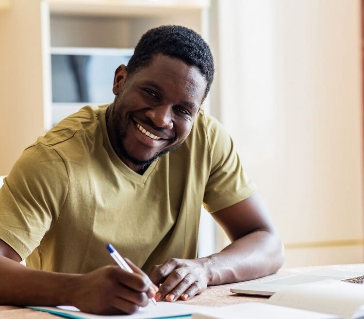 black man sitting at a desk filling out paper applications