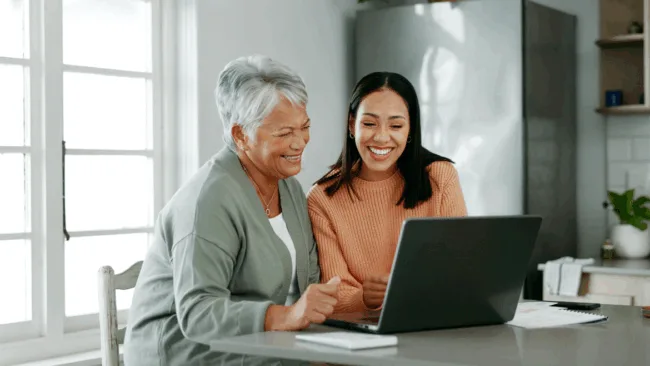 Dos mujeres sentadas en una mesa revisando sus finanzas