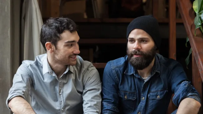 Two men having a conversation on the stairs.