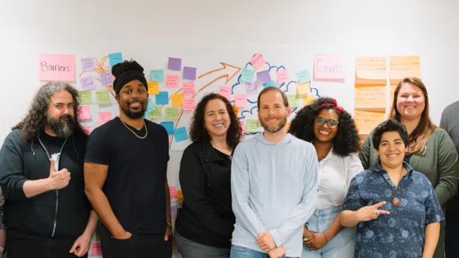 GreenPath team photo in-front of a white board with goals. 
